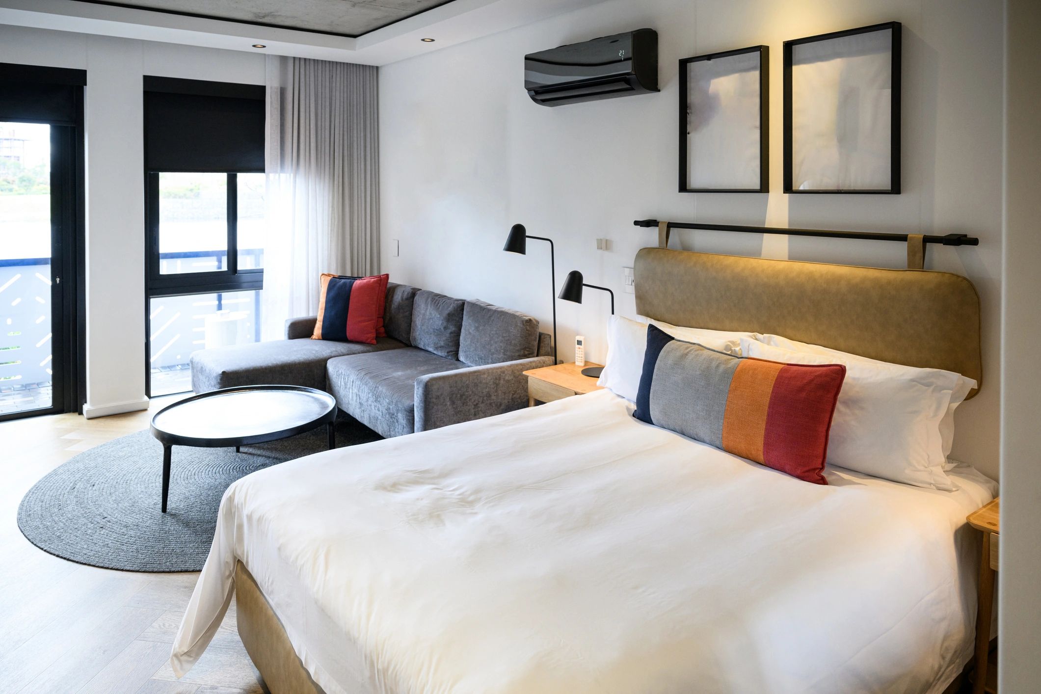 Contemporary hotel room with a king bed and warm minimalist design